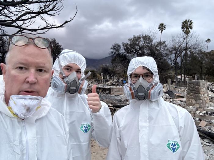 Family members in protective equipment during Eaton Fire cleanup