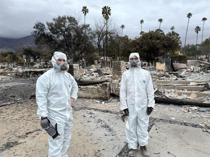 Family members standing at the burned property after the Eaton Fire